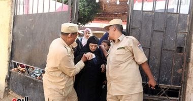 الأمن الإنسانى.. شرطى يساعد سيدة عجوز للوصول للجنتها الانتخابية فى العياط
